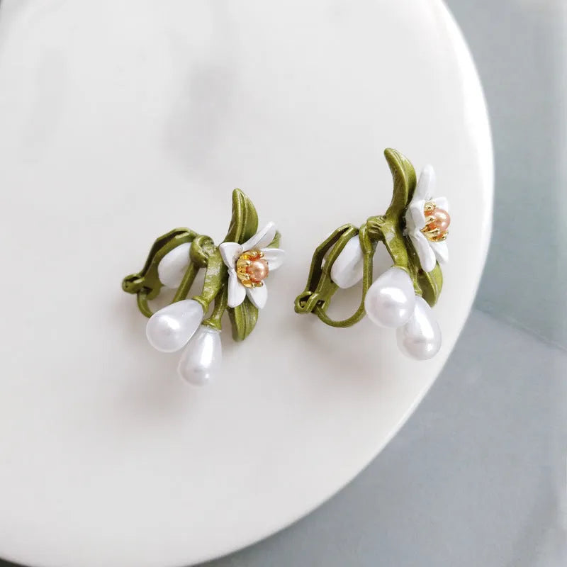 A pair of alloy flower earrings for women, showing sterling silver needle flower studs and a matching flower clip-on style.