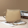 Soft genuine cowhide women's messenger bag in a square vertical shape with a loading handle.