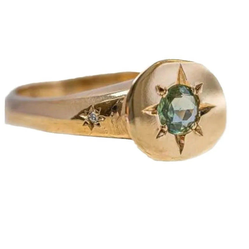 Golden oval ring with a central star-shaped zircon stone on an adjustable band.
