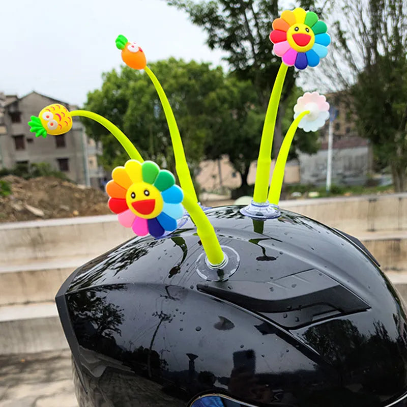 Yellow silicone sunflower helmet decoration with a black suction cup base attached to a helmet.