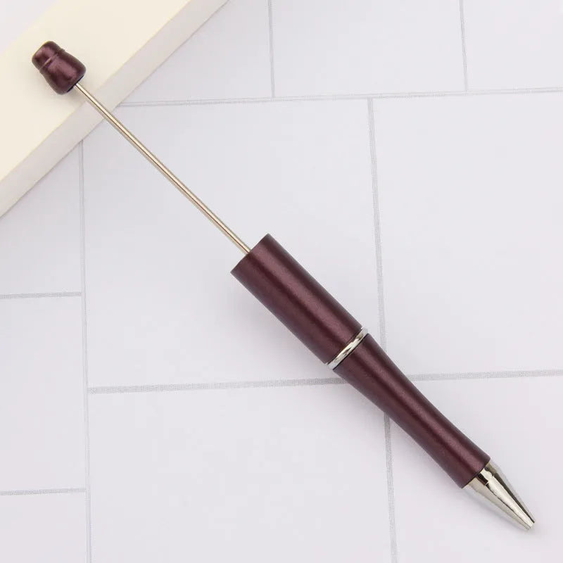 Colourful spinning ballpoint pen with plastic beads on a white background.