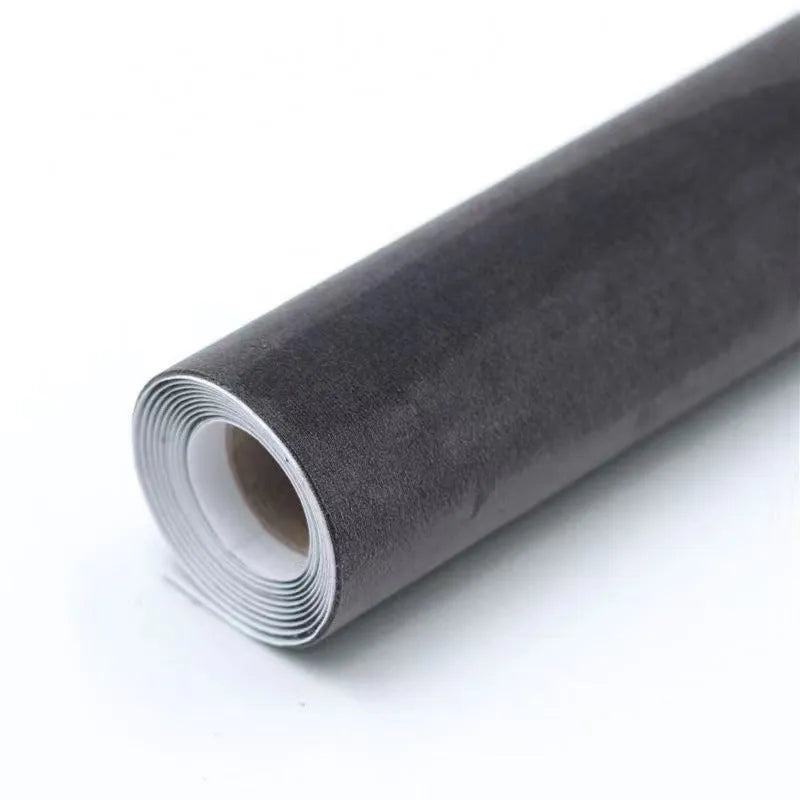 Roll of self-adhesive leather suede fabric in BMW brown colour next to a car dashboard.