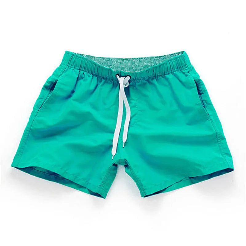 Men's straight-leg polyester beach shorts in black, shown on a model, highlighting the distressed finish and casual fit.