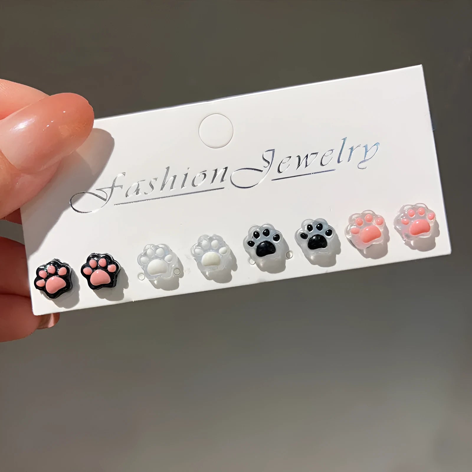 Cat paw magnetic ear clips in transparent pink colour with plastic resin finish, packaged as one pair