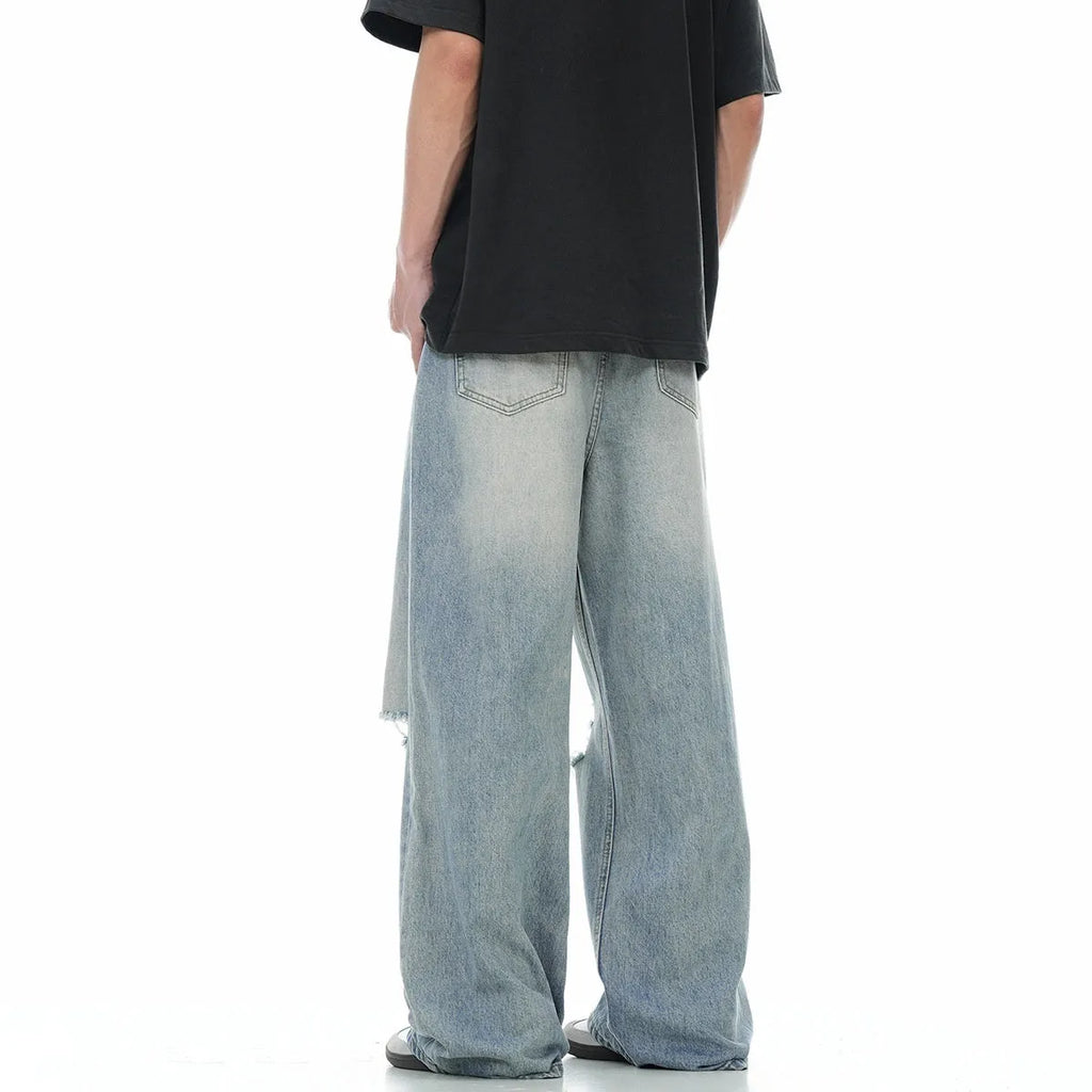 Men's blue straight-leg jeans with distressed ripped details and a zipper fly.