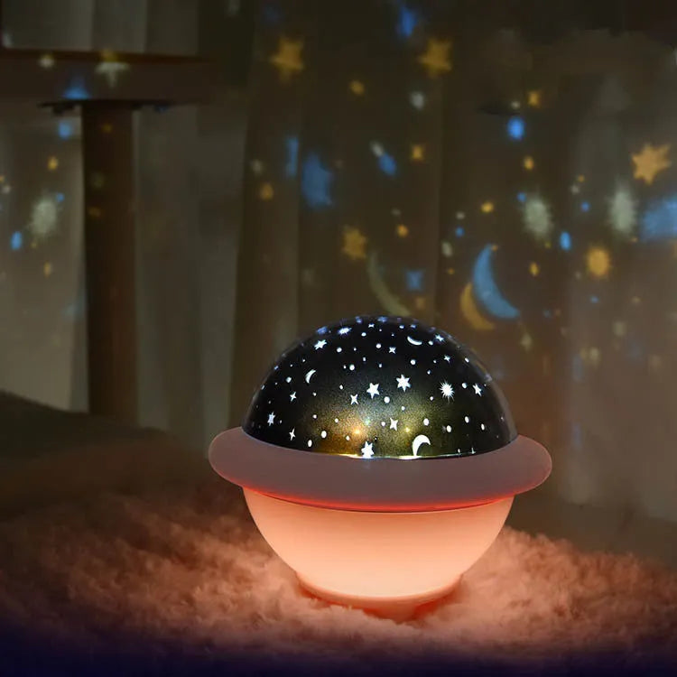 Green UFO-shaped plastic LED night light projecting a starry sky pattern, shown with a USB cable.