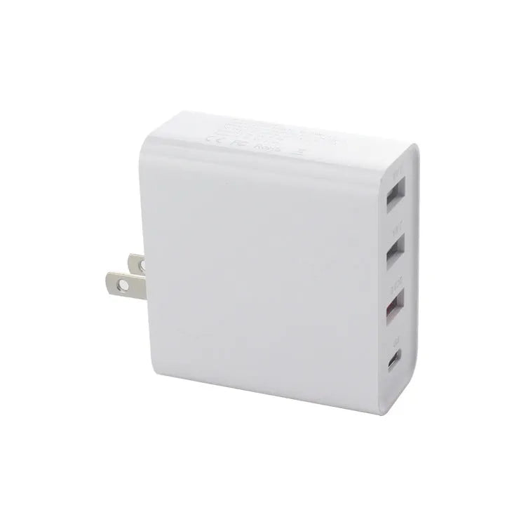 Black 48W desktop charger with four USB-C ports and a white UK plug on a wooden table.