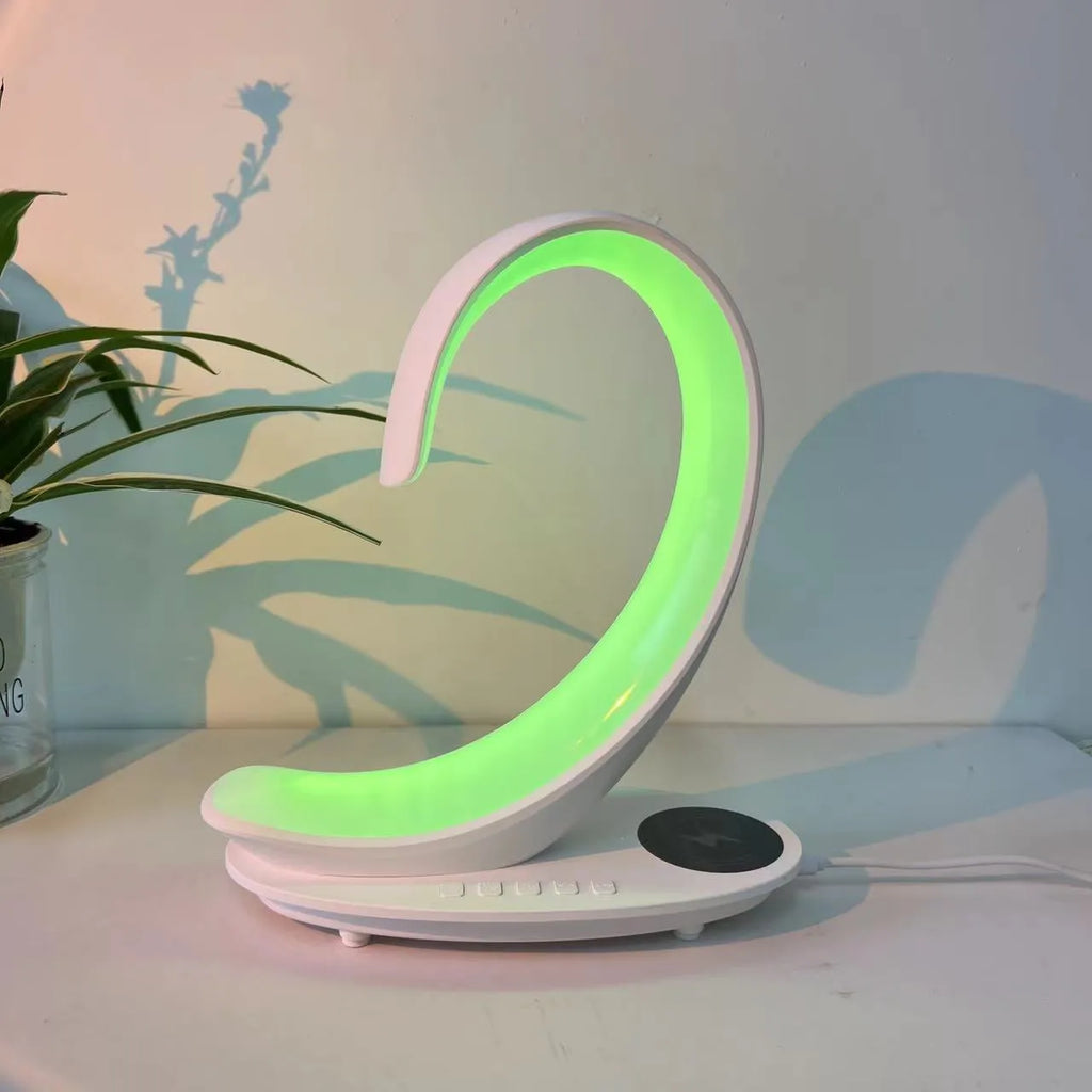 White swan-shaped desktop device functioning as a wireless charger, Bluetooth speaker, and colourful LED atmosphere lamp.