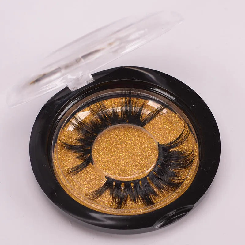 A pair of black 5D false eyelashes made from mink hair with an application brush and storage cap.