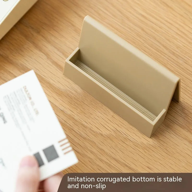 Creative PS geometric business card stand in brown, holding 20 cards upright on a desk.