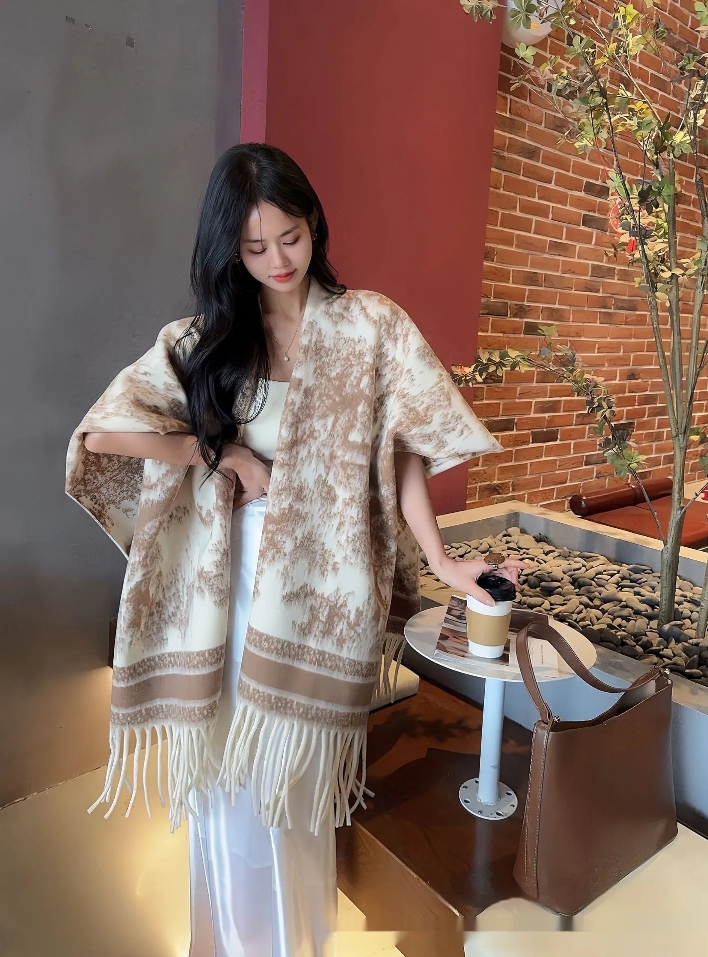 Women modelling a lightweight polyester scarf cape with tassels in a casual shawl style.