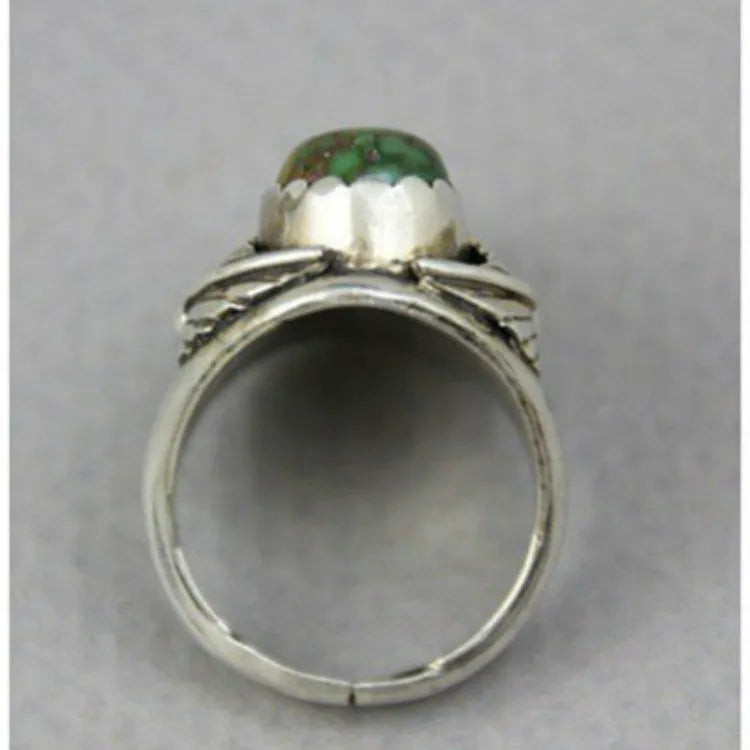 Close-up of a women's geometric turquoise alloy ring on a grey background.