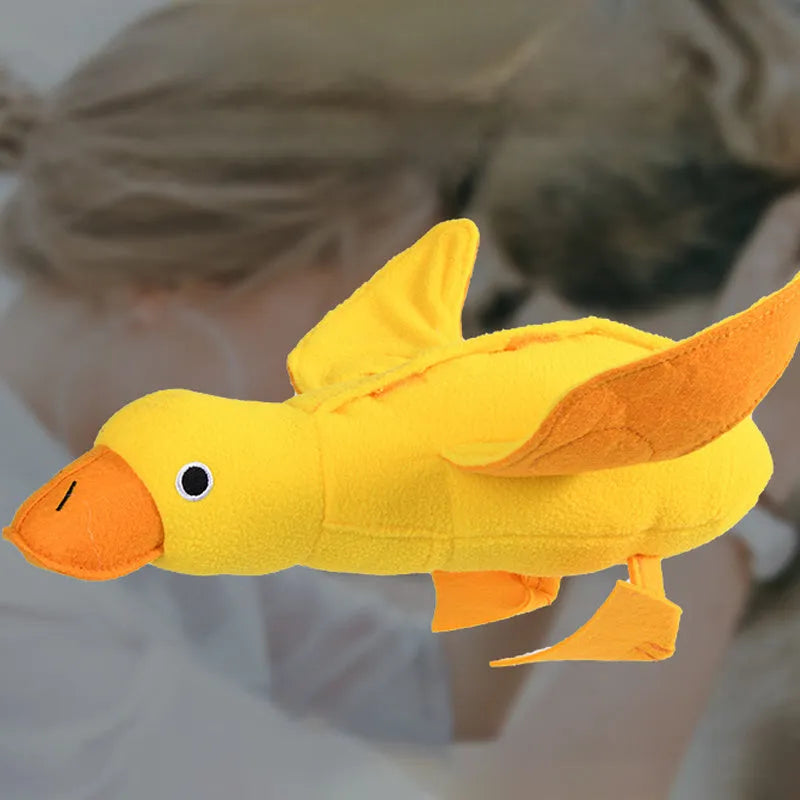 Yellow plush duck dog training toy with a squeaker and treat compartments on a white background.
