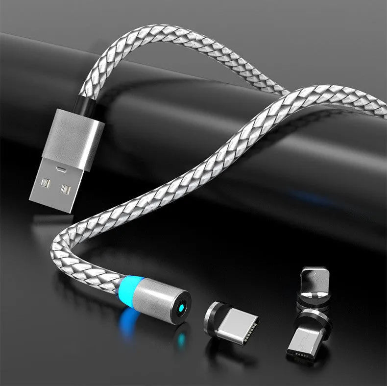 Magnetic charging cable with glowing LED light connected to a phone, showing black and silver colour options on a desk.