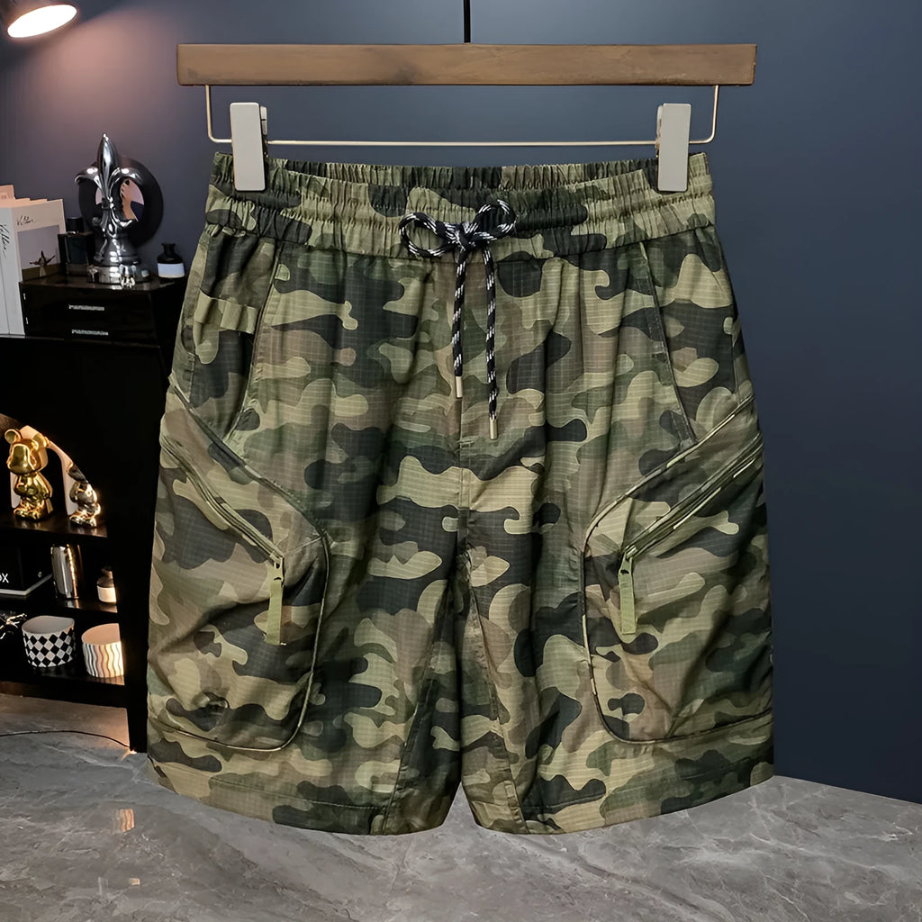 Man wearing olive camouflage cargo shorts with a loose fit and cargo pockets.