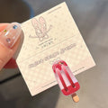 Cartoon ice cream design resin hair barrette clip in side view showing colour options.