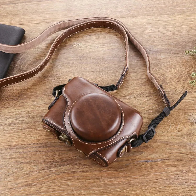 Black imitation leather portable card camera bag with crossbody strap on a solid background