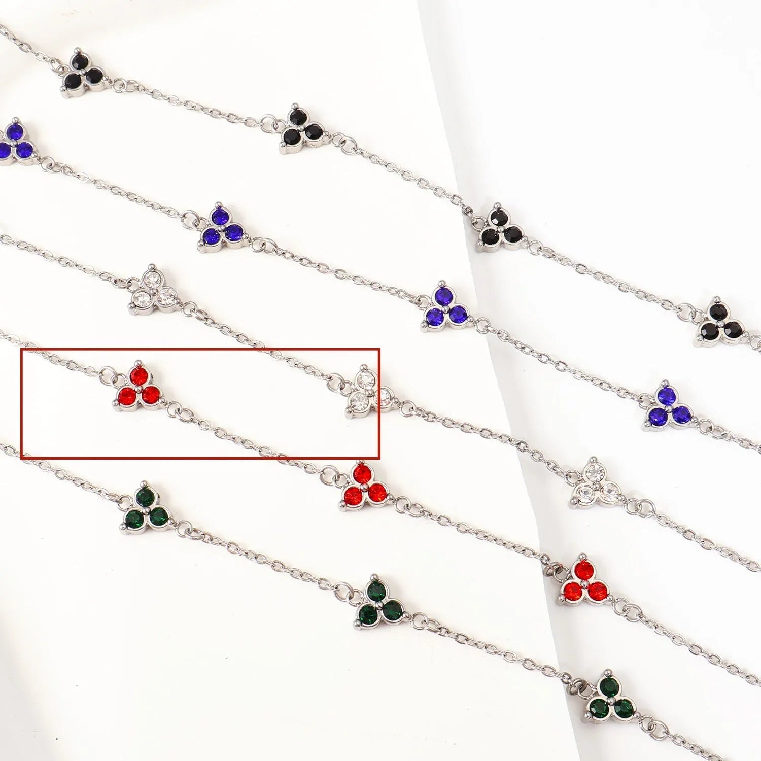 Geometric stainless steel women's bracelet with triangular links and a coloured stone centre.