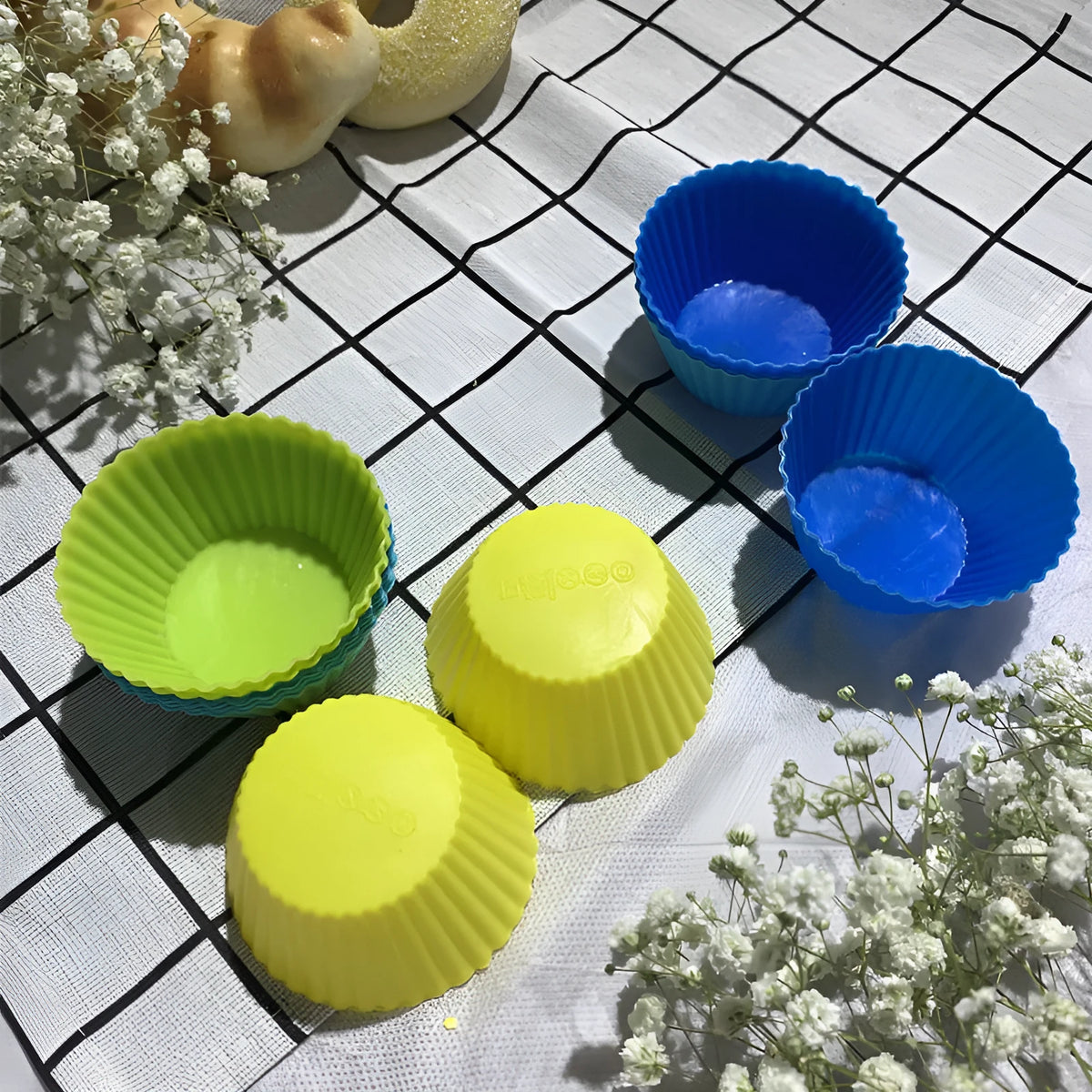 Twelve reusable silicone cupcake liners in six colours, two cups per colour, with a nonstick surface.