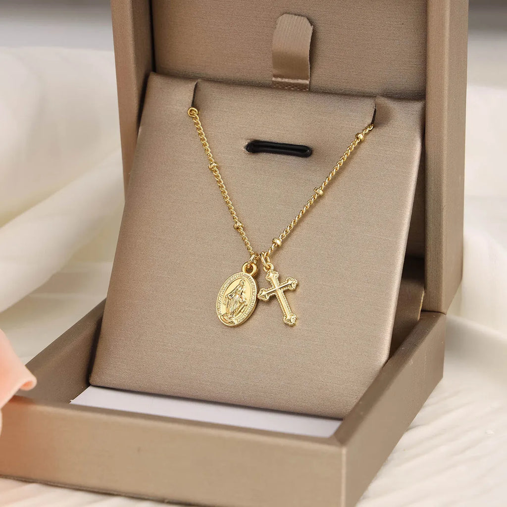 Geometric Virgin Mary cross pendant on a 45cm gold-coloured chain with an adjustable lobster clasp.