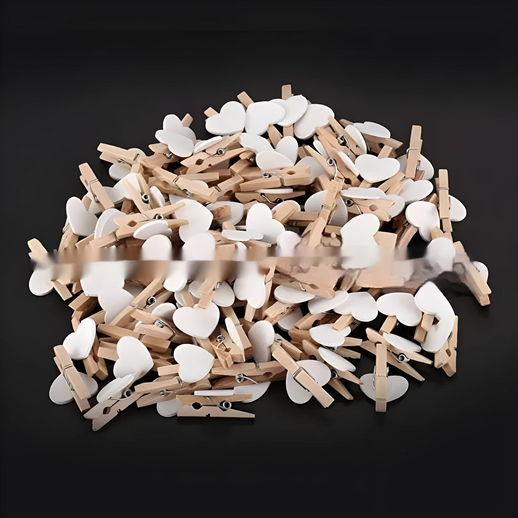 Set of five handmade solid wood heart-shaped clips in assorted colours on a wooden surface.