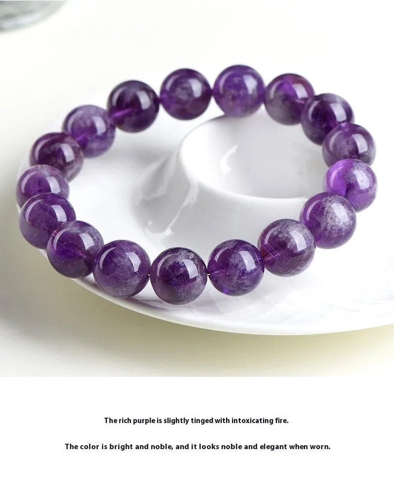Natural feather amethyst bracelet with geometric Ruyi beads in snow mountain purple colour on a wrist.