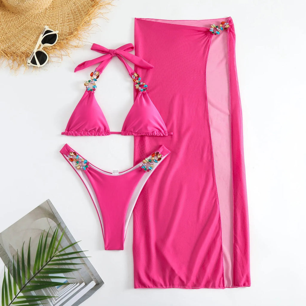 Rose red three-piece swimsuit bikini set with a long mesh skirt laid flat.
