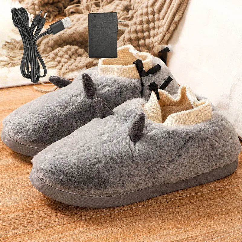USB electric foot warmer slippers in grey with a connected USB cable on a wooden floor.