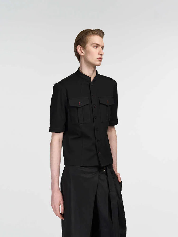 Handmade black half-sleeve hunting shirt with a shirt collar on a hanger.