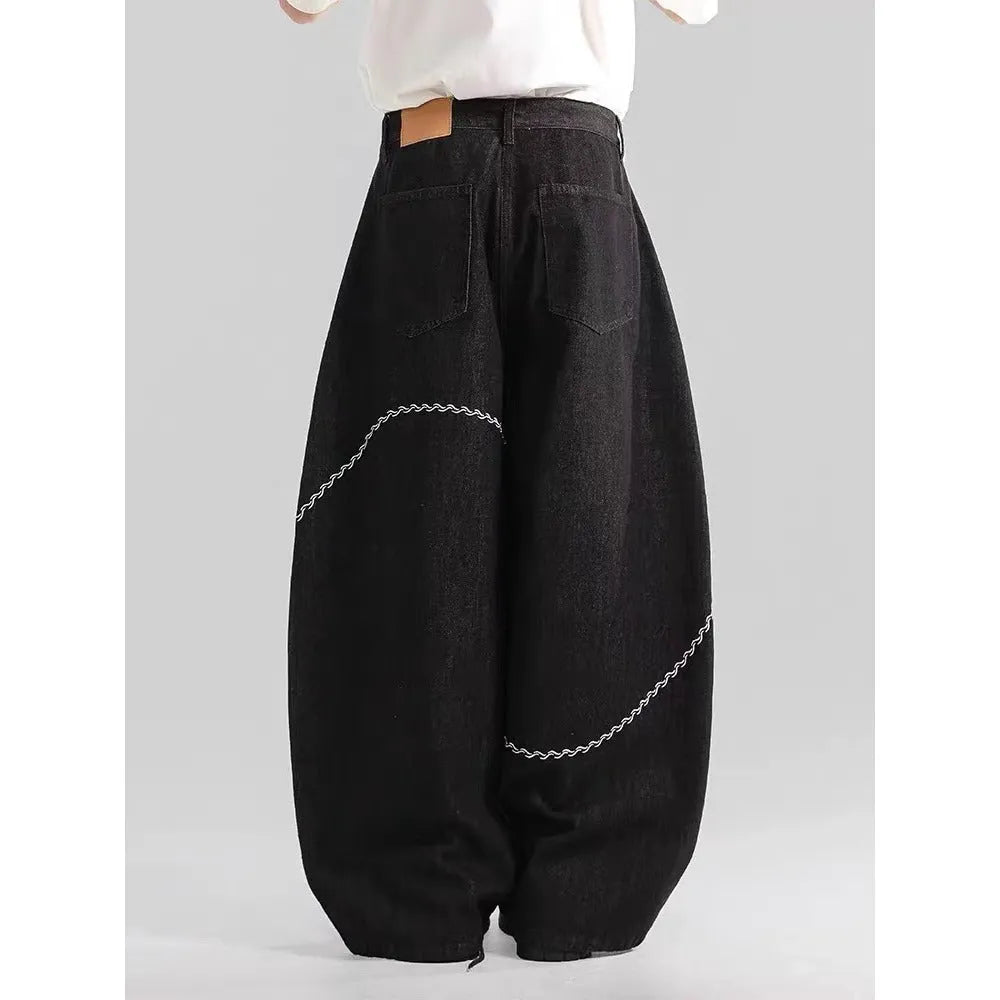 Black straight-leg denim trousers with a mid-waist fit and micro-elastic waistband on a hanger.