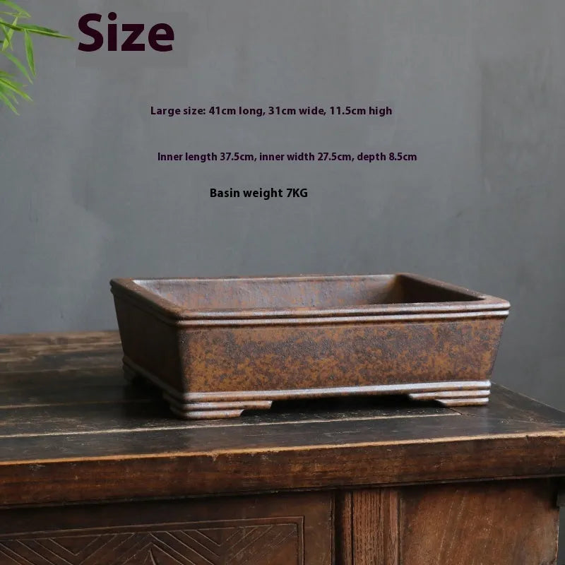 Rectangular purple sand bonsai pot with shallow basin, shown empty on a wooden surface.
