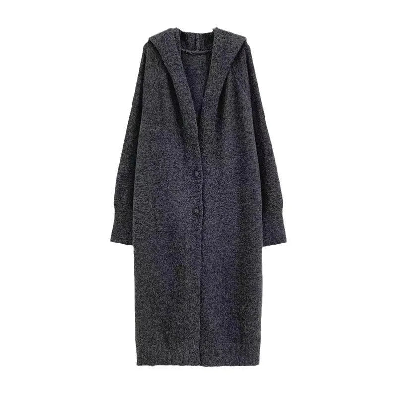 A woman wearing a long, loose-fitting, hooded knitted cardigan in a solid colour, showcasing its below-the-knee length.