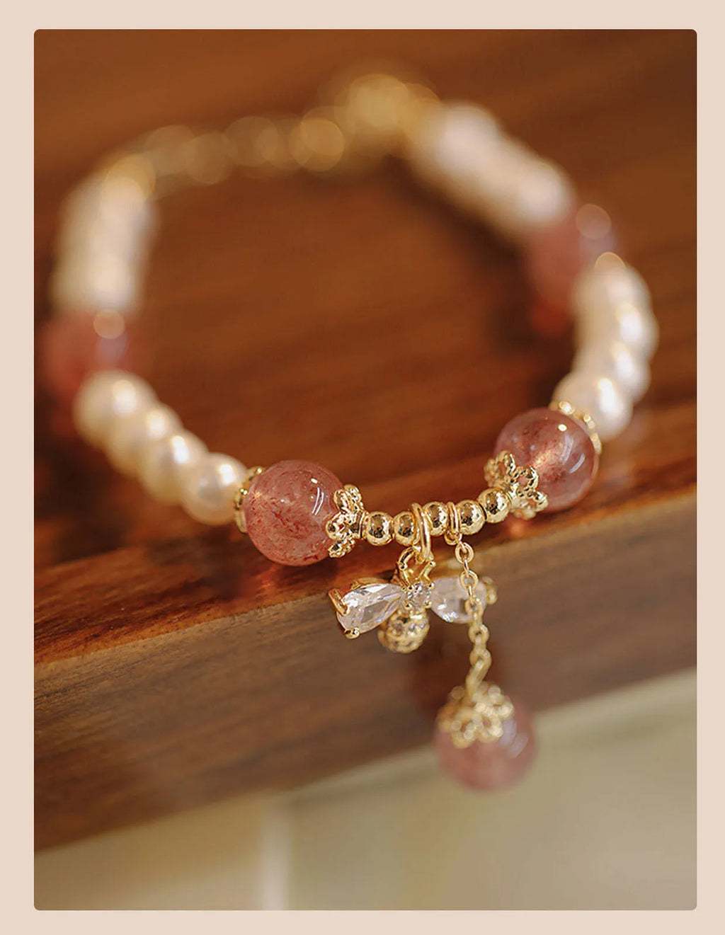 Handmade women's strawberry quartz crystal bracelet with a decorative bow clasp.