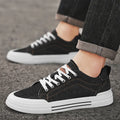 Men's low top canvas sneakers in black or blue with front lace-up fastening and injection moulded plastic sole, sizes 39-48