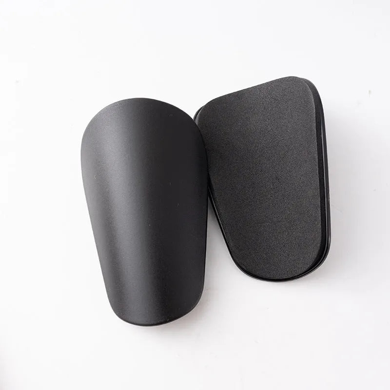 Two pairs of PU mini shin guards for sports protection in various colours on a white background.