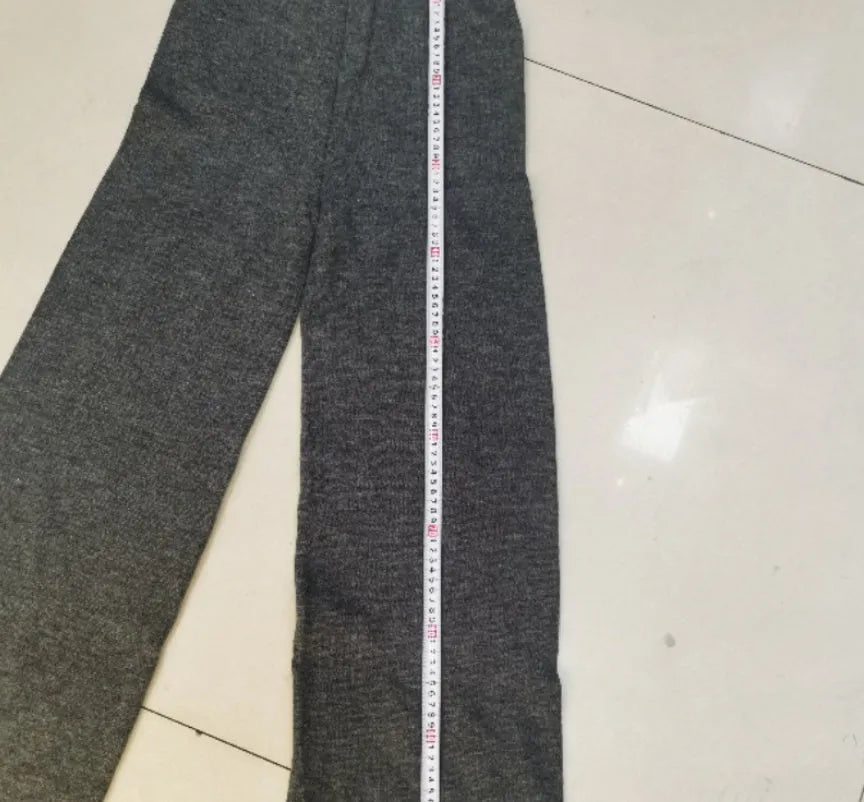 Women's dark grey acrylic knit set with side-slit top and full-length trousers laid flat.