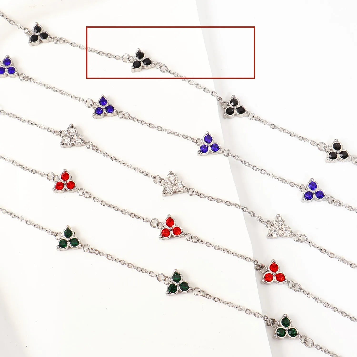 Geometric stainless steel women's bracelet with triangular links and a coloured stone centre.