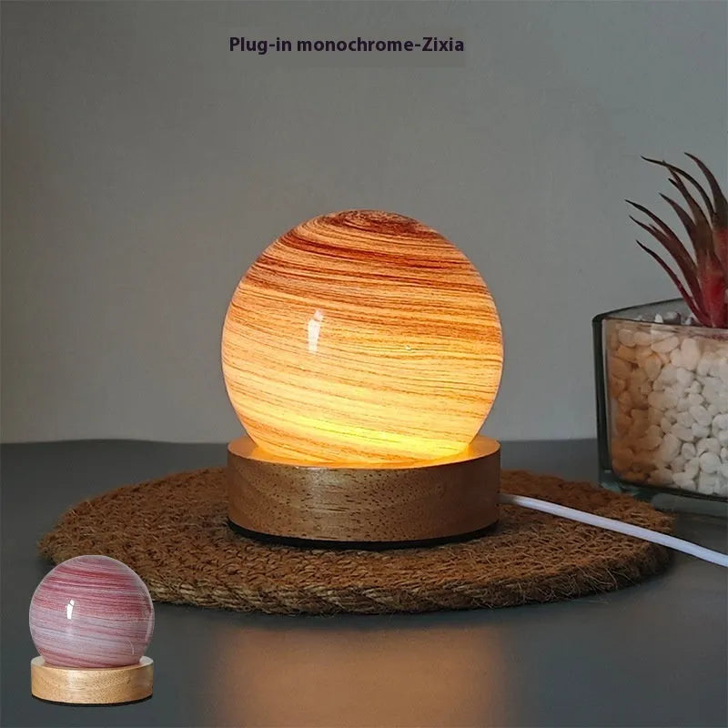 Modern planet-shaped USB night light on its base with dimmable multi-colour glow