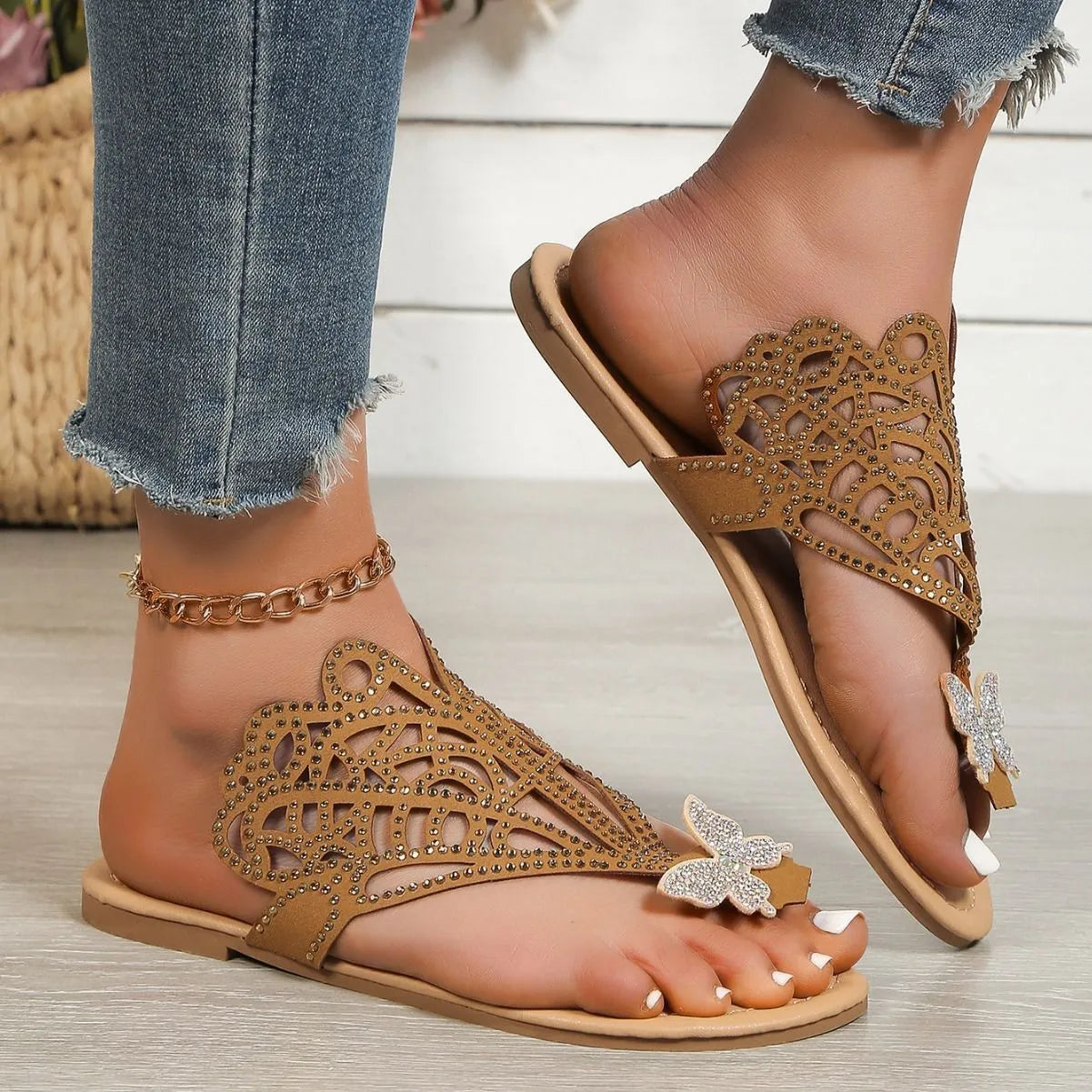 Black women's flat-heeled slip-on sandals with a flip-toe design and rhinestone decoration.