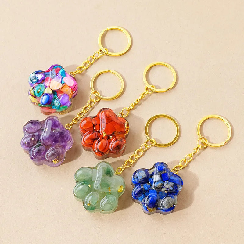 Hand-carved natural crystal cat's paw keychain pendant on a metal ring, showing unique gemstone colour.