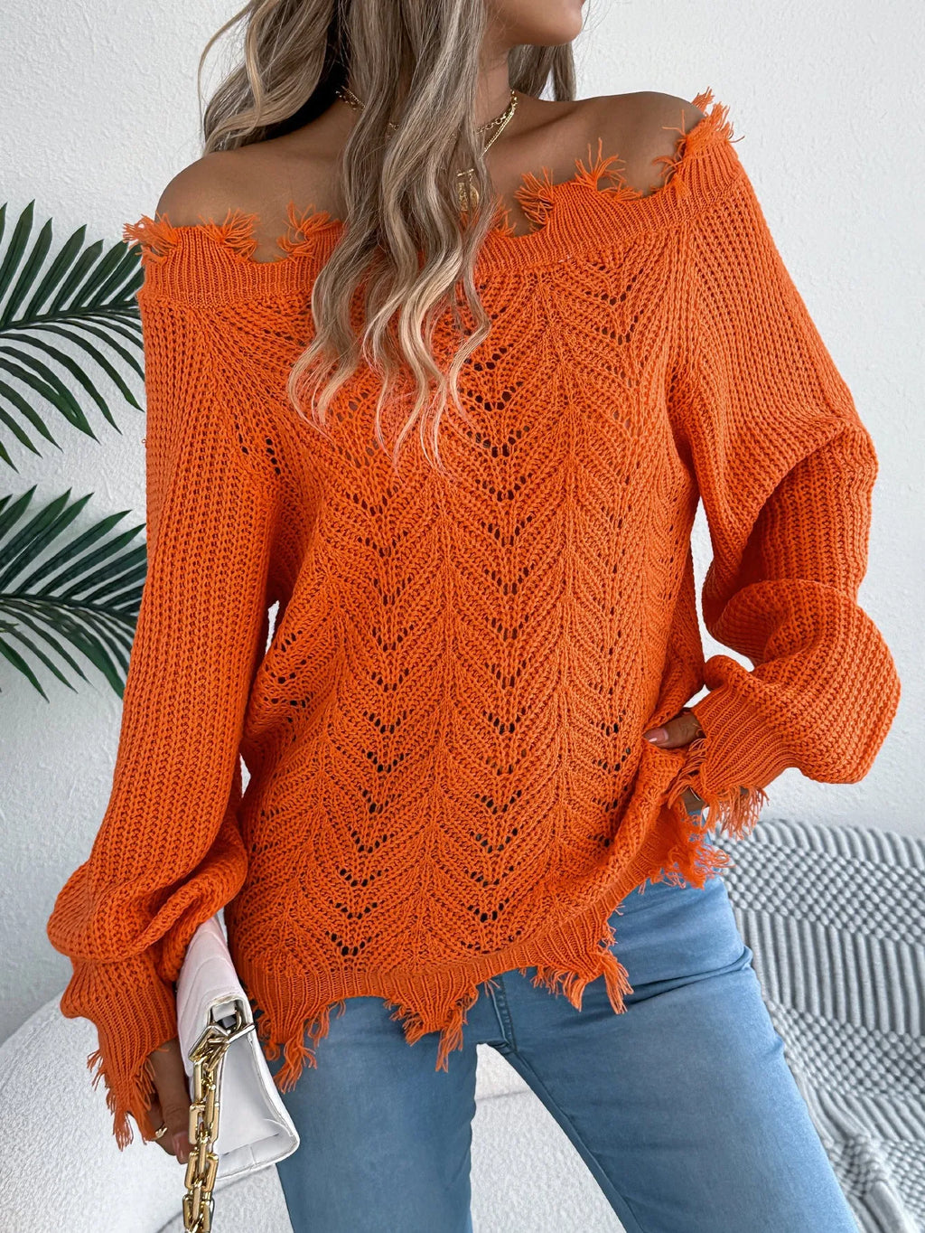 Women's white cut-off-the-shoulder long sleeve pullover sweater with hollow-out detail on front.