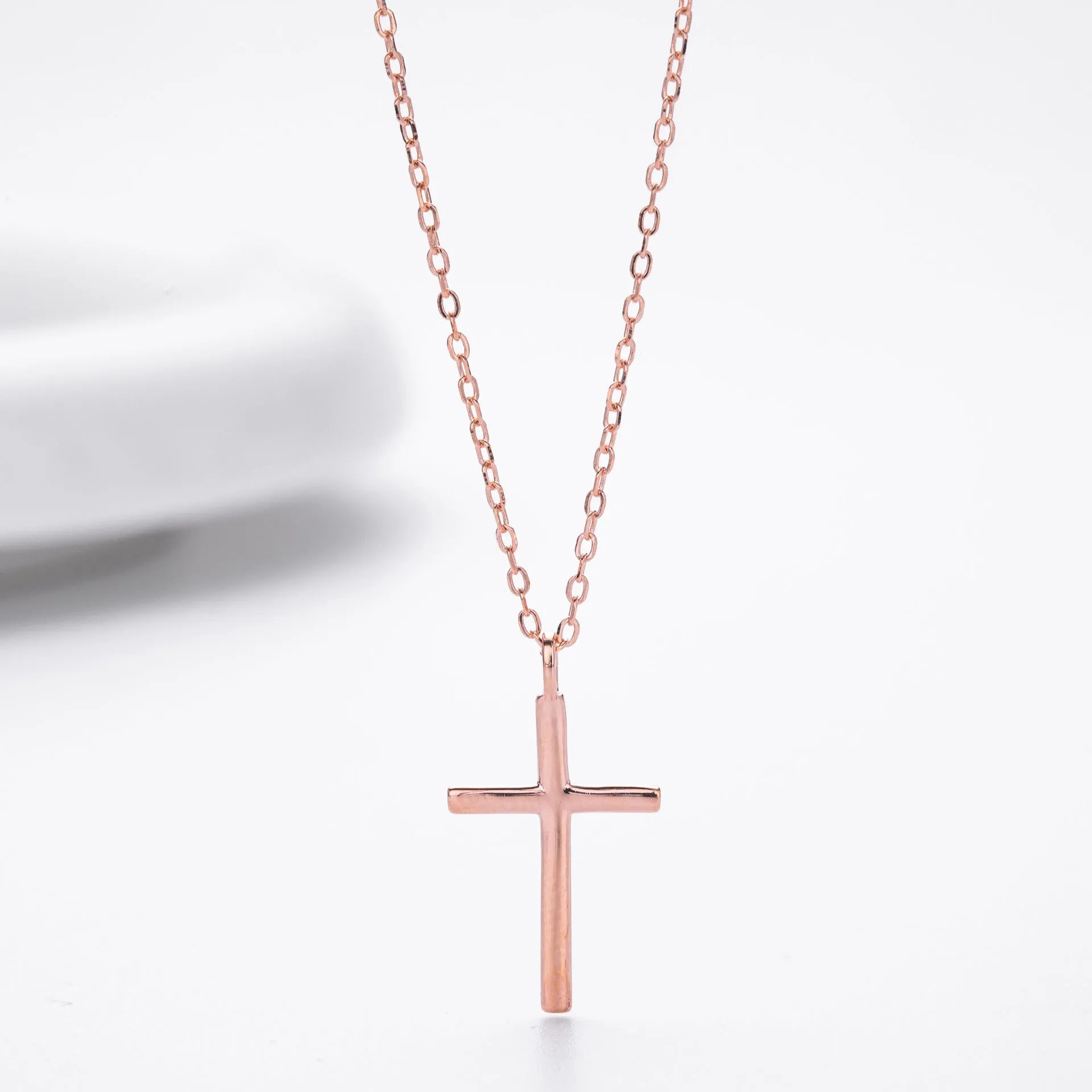 S925 sterling silver necklace with a simple glossy cross pendant on an O-shaped chain in a choice of gold, platinum, or rose gold plating.