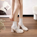 Women's black patent leather chunky heel shoes with a round toe and buckle fastening.