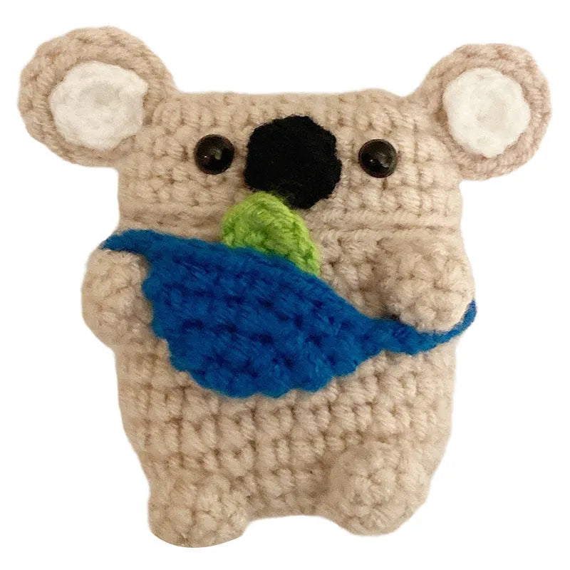 Hand-knitted grey koala bear backpack design earphone cover for Apple AirPods on a table.