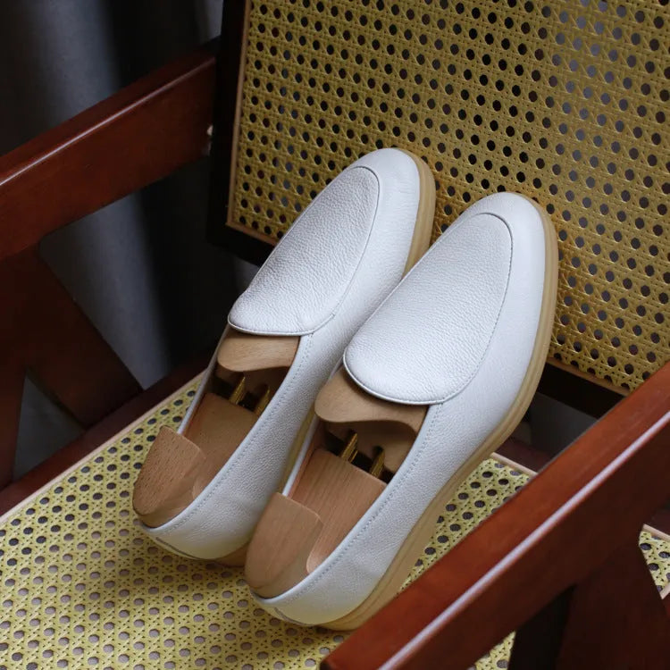 British handmade men's brown leather loafers with a flat TPR sole on a white background.