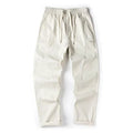 Casual wide-leg cotton trousers in milky white on a model, showing the relaxed fit and trousers-mouth silhouette.