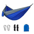 Blue nylon parachute camping hammock hung between two trees, showing its full 270cm length and 140cm width.