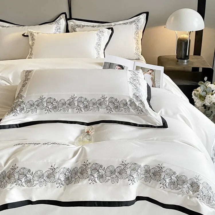 120 thread count pure cotton embroidered four-piece bedding set in solid grey colour on a bed