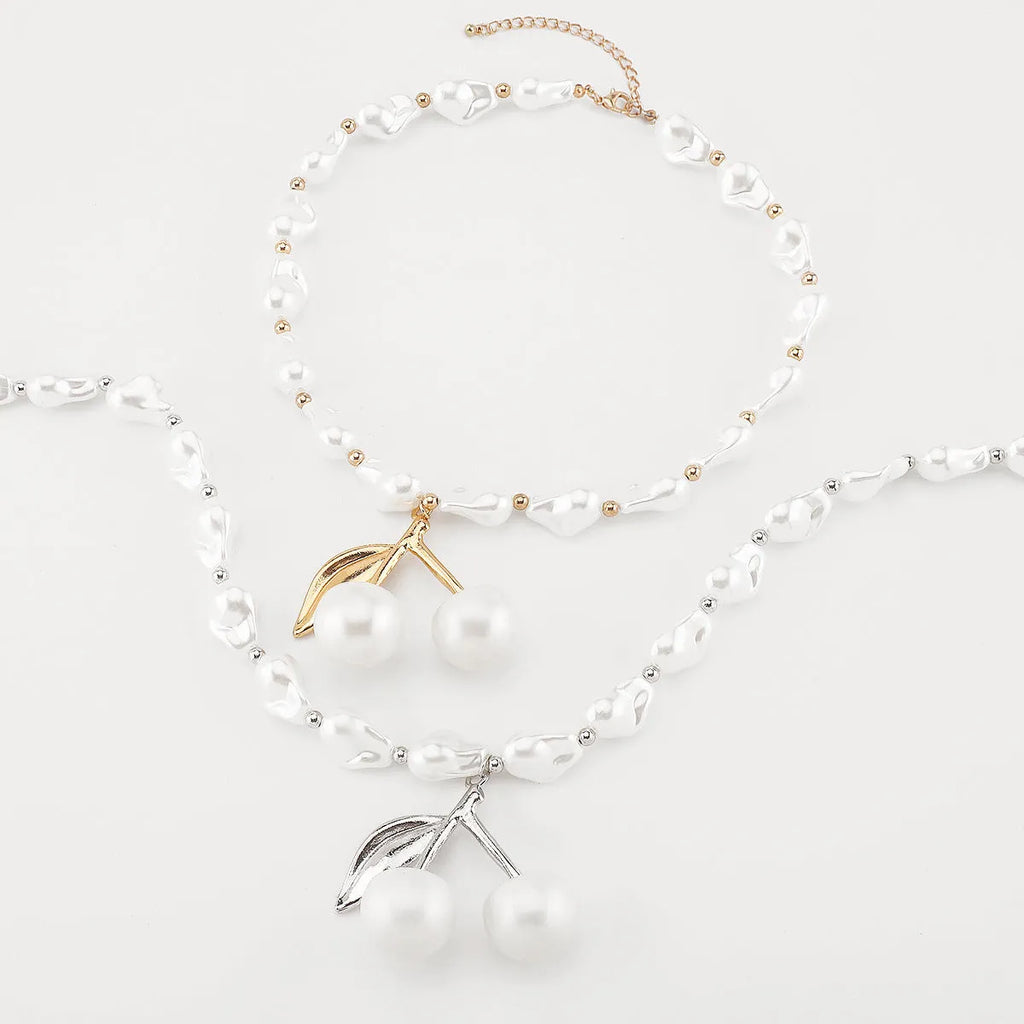 Gold irregular cherry fruit pendant on a white imitation pearl chain necklace, adjustable from 51 to 60 cm.