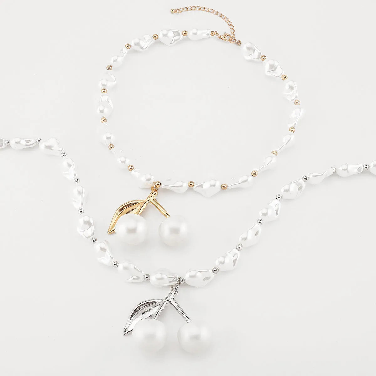 Gold irregular cherry fruit pendant on a white imitation pearl chain necklace, adjustable from 51 to 60 cm.